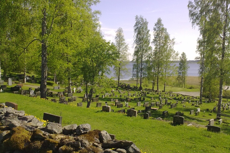 Kirkkoniemen hautausmaan rinteen hautoja. Taustalla Tohmajärvi.